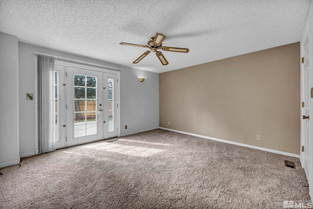 carpeted spare room with visible vents, a textured ceiling, french doors, baseboards, and ceiling fan