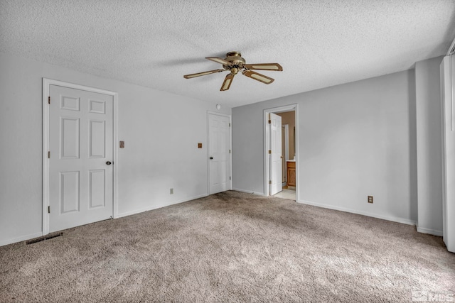 unfurnished room with a ceiling fan, visible vents, baseboards, a textured ceiling, and carpet flooring