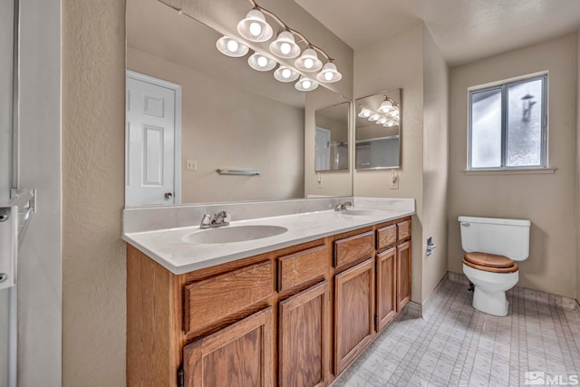 bathroom featuring double vanity, toilet, tile patterned floors, and a sink