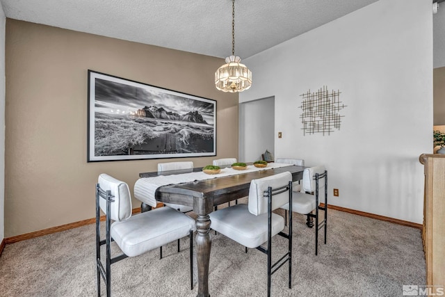 carpeted dining area with a textured ceiling and baseboards