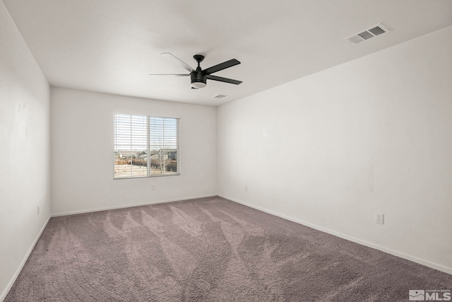 carpeted empty room with visible vents, baseboards, and a ceiling fan