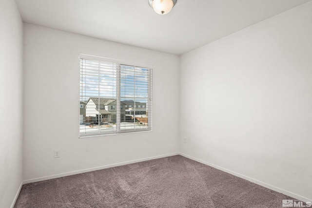 carpeted spare room featuring baseboards