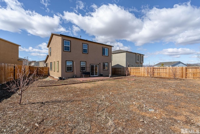 rear view of house featuring a patio, a fenced backyard, and stucco siding