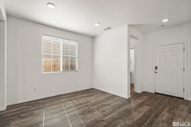 empty room with recessed lighting, wood finished floors, visible vents, and baseboards