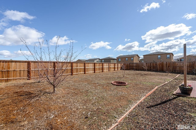 view of yard featuring a fire pit and a fenced backyard