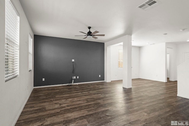 unfurnished room with visible vents, plenty of natural light, wood finished floors, and a ceiling fan