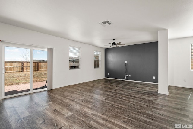 unfurnished living room featuring dark wood finished floors, visible vents, baseboards, and a ceiling fan