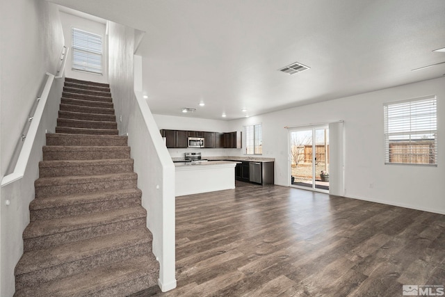 stairway with recessed lighting, visible vents, and wood finished floors