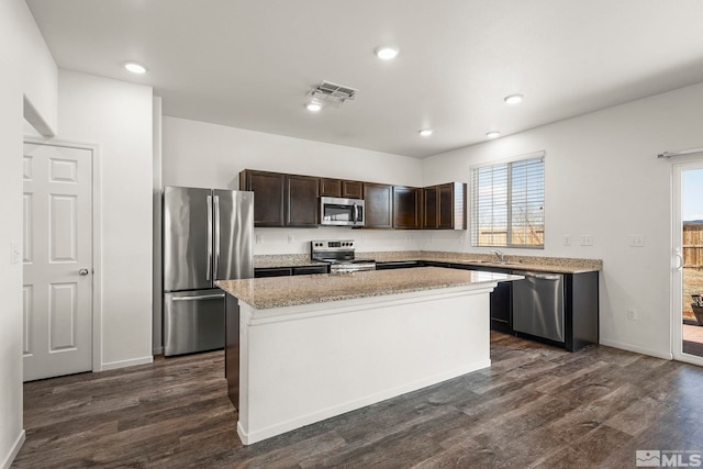 kitchen featuring a center island, dark wood-type flooring, dark brown cabinetry, stainless steel appliances, and a sink