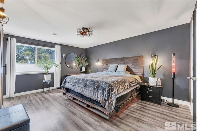 bedroom with baseboards and wood finished floors