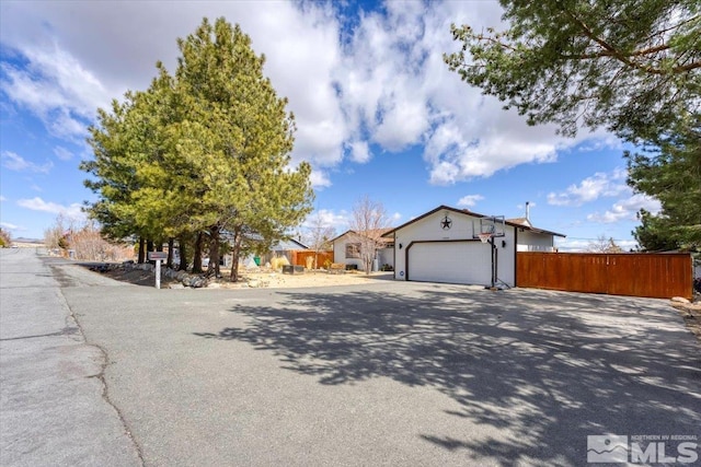 view of front of property with concrete driveway, fence, and a garage