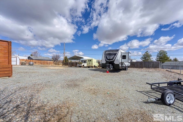 view of yard featuring an outdoor structure, a storage unit, and fence