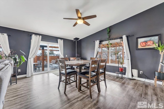 dining room featuring baseboards, lofted ceiling, wood finished floors, and a ceiling fan