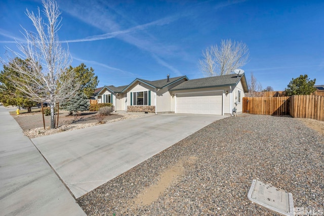 ranch-style home featuring a garage, concrete driveway, and fence