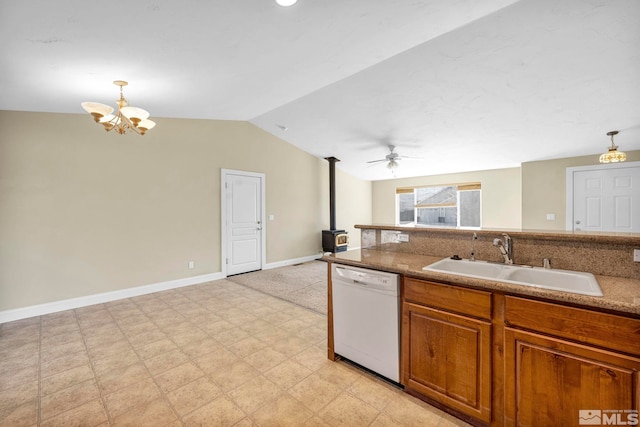 kitchen featuring a wood stove, a sink, vaulted ceiling, dishwasher, and brown cabinets