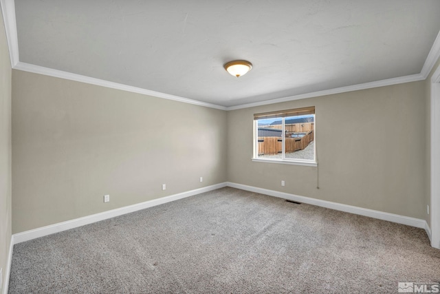 spare room featuring visible vents, baseboards, carpet floors, and crown molding