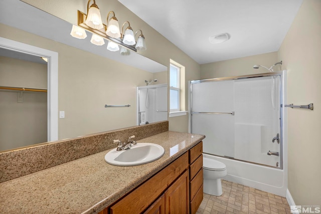 full bath featuring a spacious closet, baseboards, toilet, enclosed tub / shower combo, and vanity