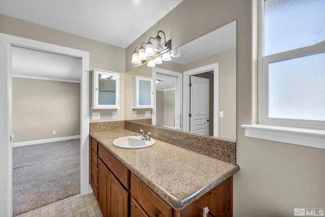 bathroom featuring baseboards, ornamental molding, and vanity