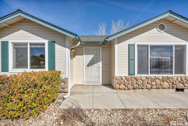 property entrance featuring stone siding