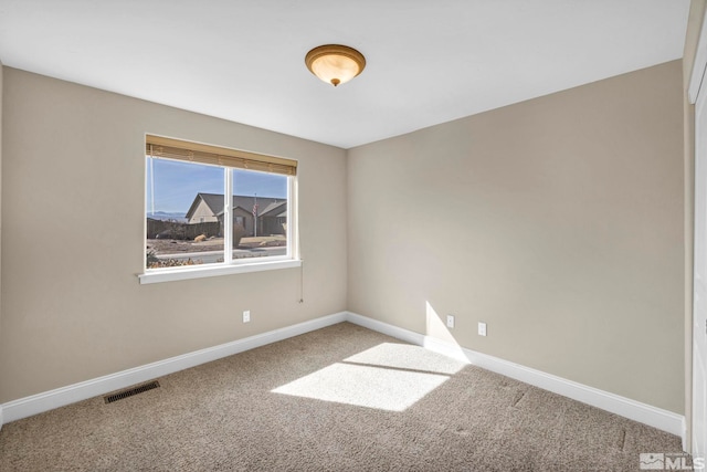 spare room featuring visible vents, carpet flooring, and baseboards