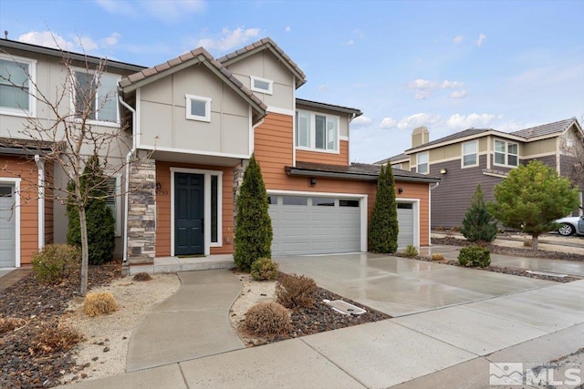 view of front facade with stone siding, an attached garage, and concrete driveway