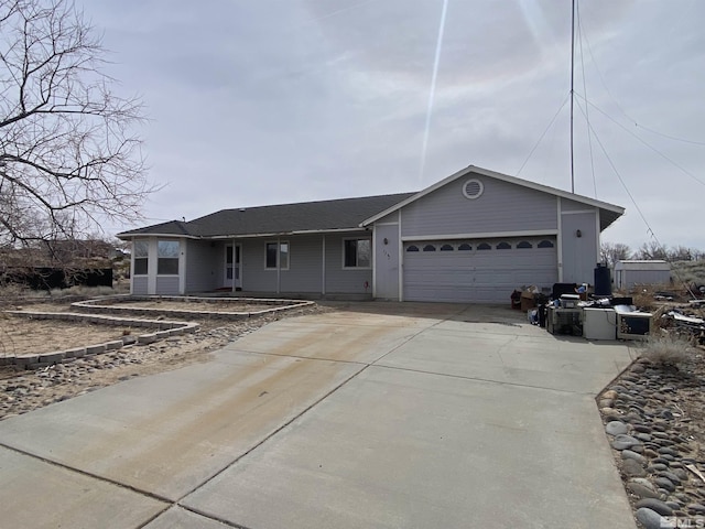 ranch-style home with concrete driveway and a garage