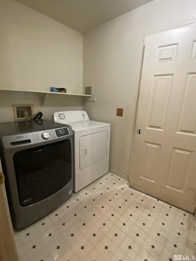 laundry area with laundry area, light floors, baseboards, and washer and clothes dryer