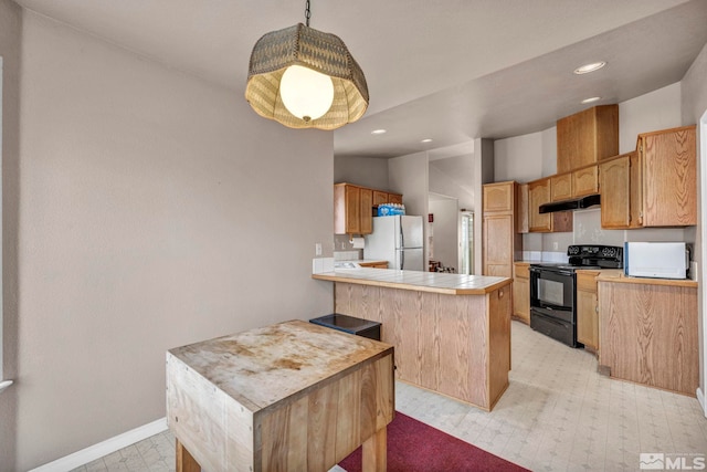 kitchen featuring under cabinet range hood, black range with electric cooktop, freestanding refrigerator, a peninsula, and light floors