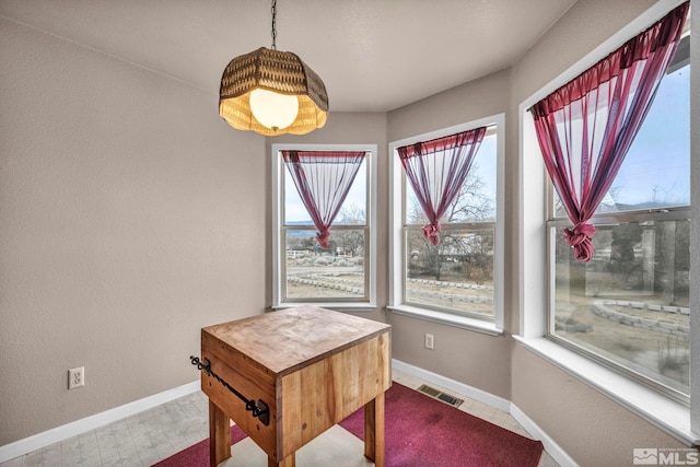 dining room featuring tile patterned floors, visible vents, and baseboards