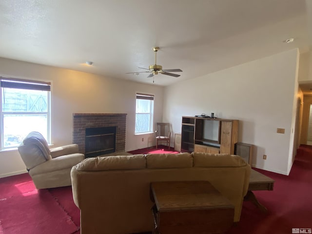 living area featuring a brick fireplace, baseboards, carpet floors, and ceiling fan