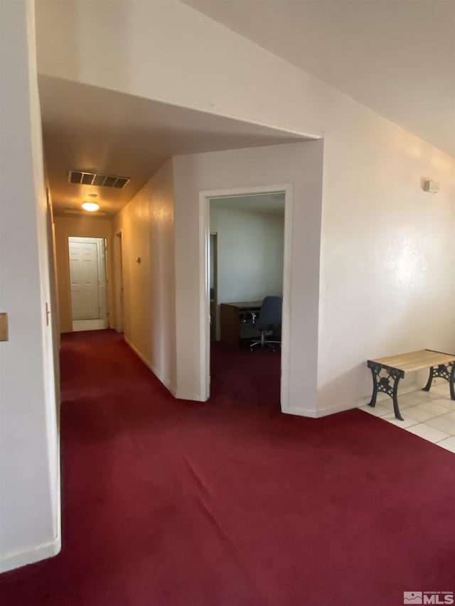 corridor with visible vents, baseboards, and carpet floors