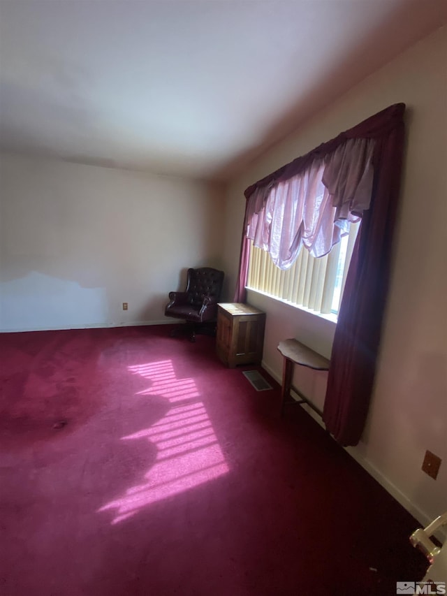 unfurnished room featuring carpet and baseboards