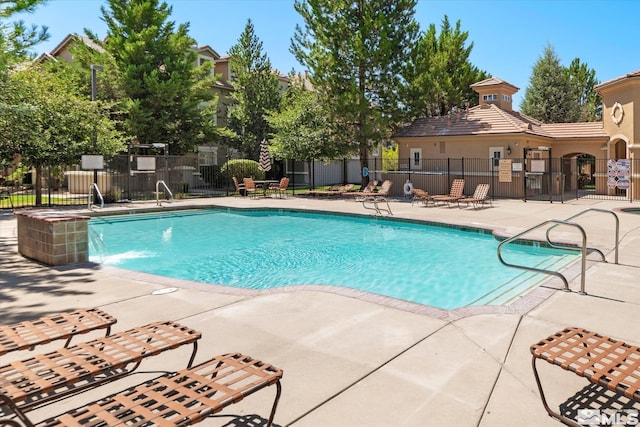 pool featuring a patio area and fence