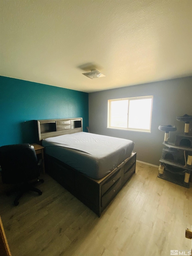 bedroom with light wood-style floors and baseboards