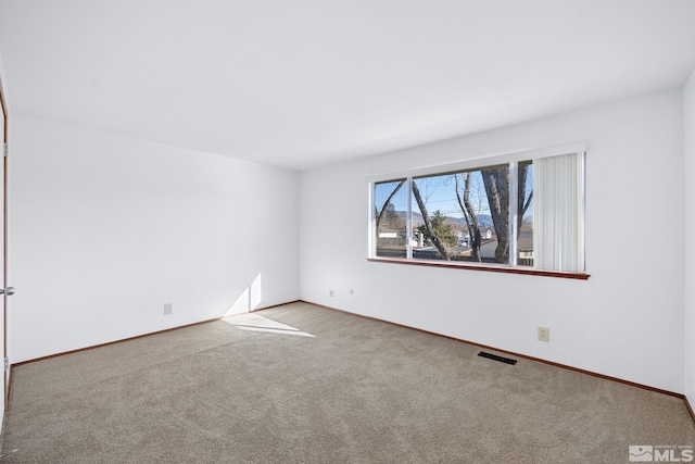 unfurnished room featuring visible vents, baseboards, and carpet