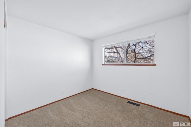 empty room featuring visible vents, baseboards, and carpet flooring