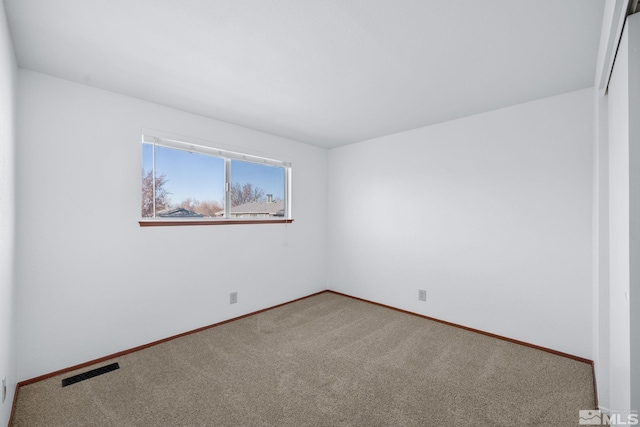 carpeted empty room featuring visible vents and baseboards