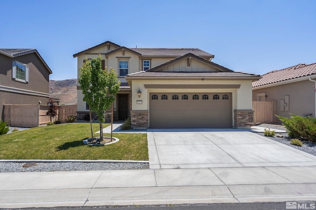 craftsman-style home featuring fence, an attached garage, concrete driveway, a front lawn, and stone siding