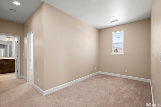 unfurnished room featuring visible vents, light carpet, and baseboards