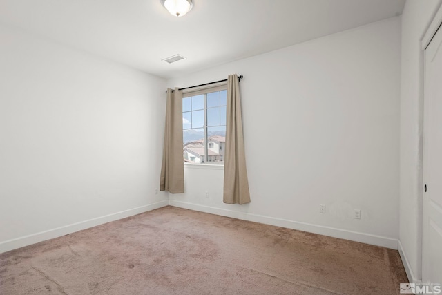 carpeted empty room featuring baseboards and visible vents