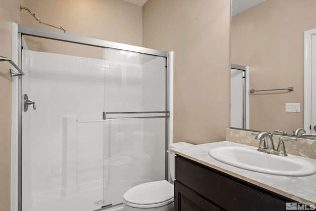 bathroom with vanity, toilet, and a stall shower