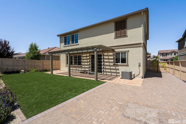 rear view of property featuring a patio area, stucco siding, a pergola, and a fenced backyard