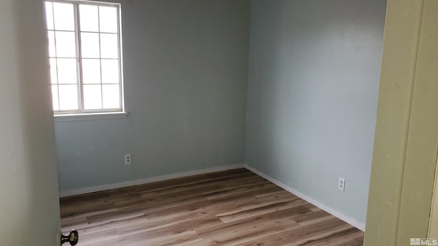 empty room featuring baseboards and wood finished floors