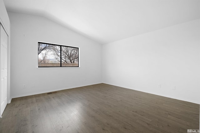 interior space featuring visible vents, lofted ceiling, a closet, baseboards, and dark wood-style flooring