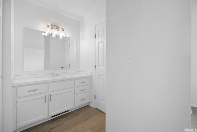 bathroom with visible vents, wood finished floors, and vanity