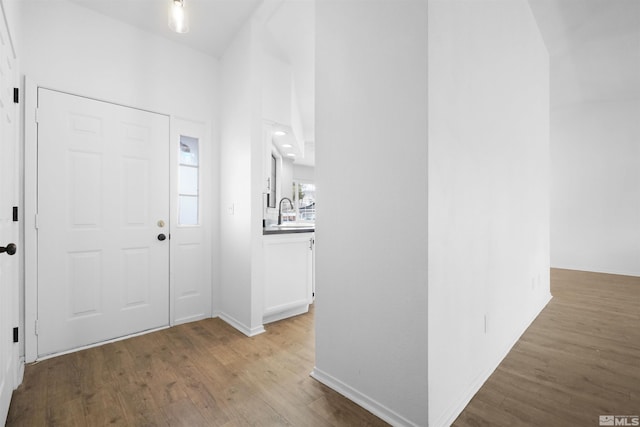 foyer with wood finished floors and baseboards