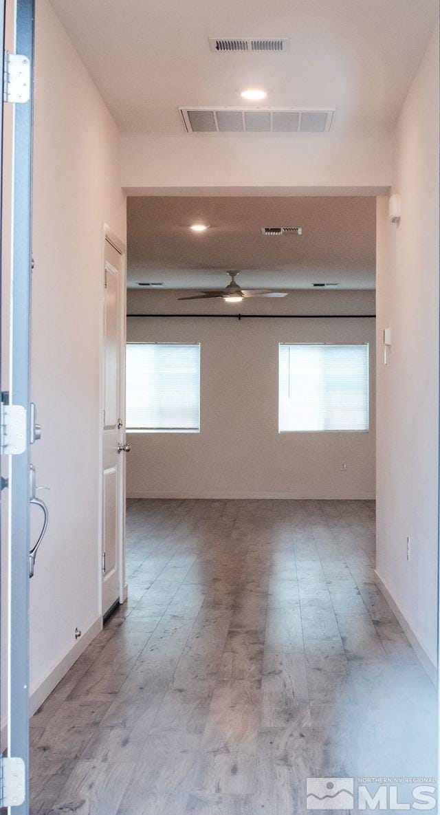 unfurnished room with a wealth of natural light, visible vents, and ceiling fan