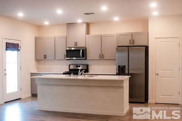 kitchen with stainless steel microwave, fridge with ice dispenser, range, and gray cabinets