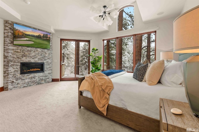 carpeted bedroom featuring access to exterior, multiple windows, and a fireplace