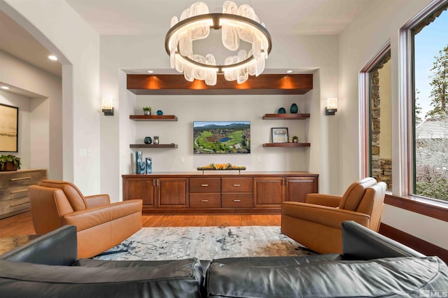 living area with light wood-style flooring, a notable chandelier, and recessed lighting